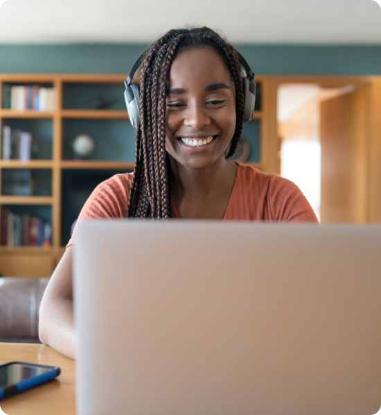 Smiling woman sitting at a laptop. 